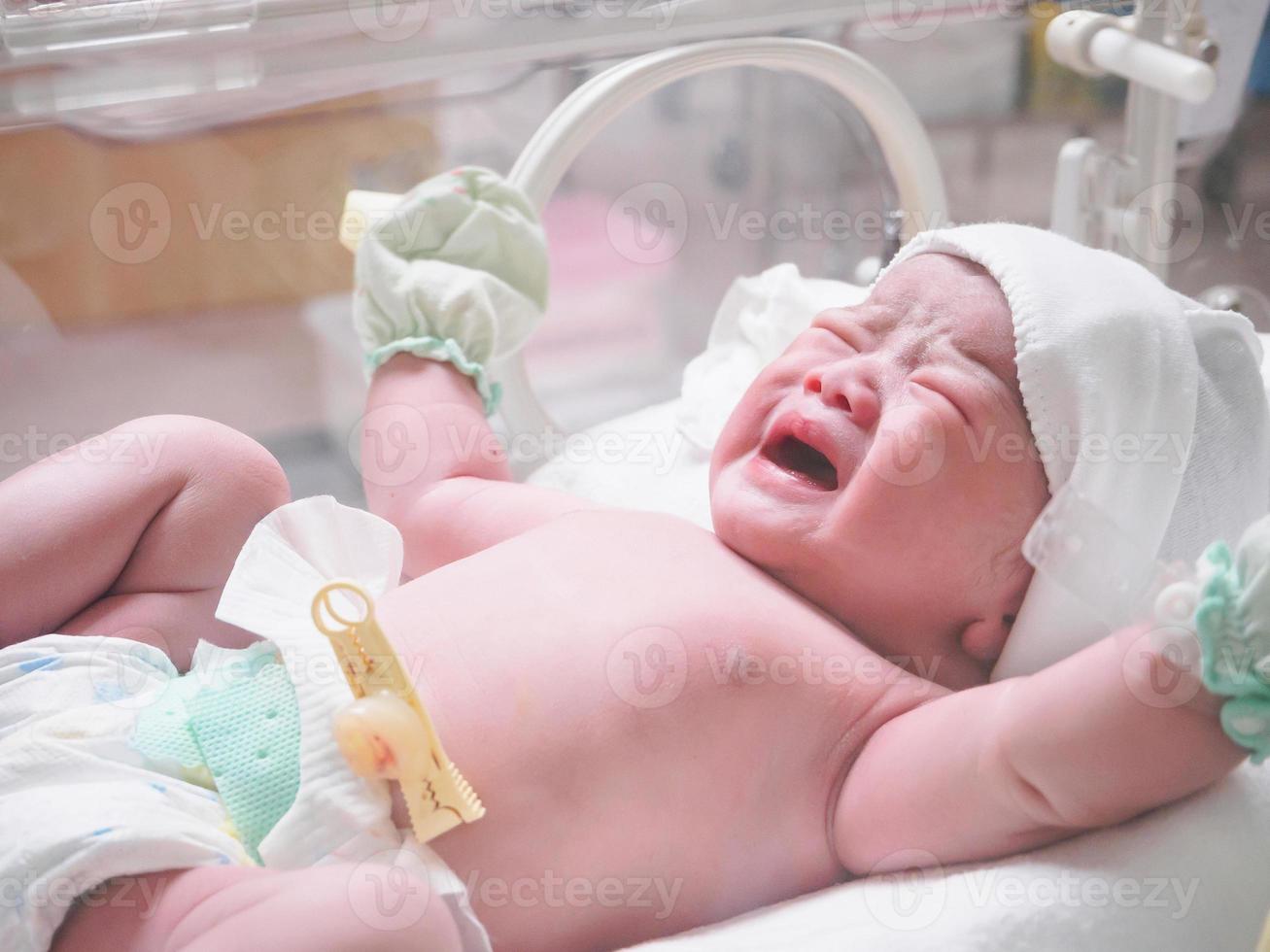 new born baby infant sleep in the incubator at hospital photo