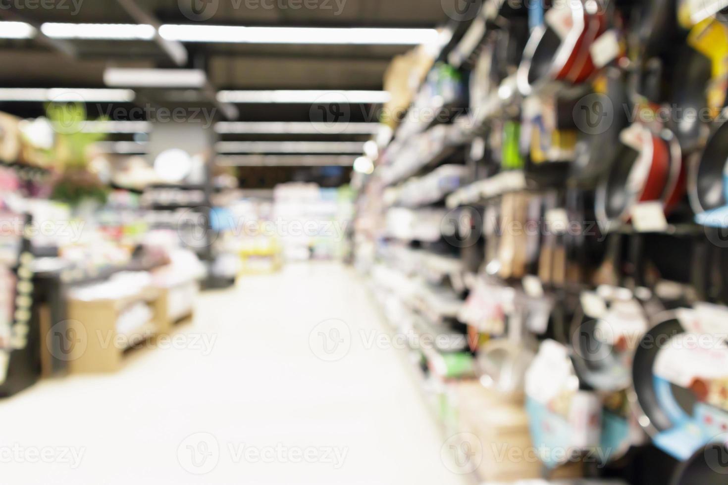 supermercado borroso abstracto con sartén antiadherente en los estantes de los utensilios de cocina en la tienda de comestibles fondo desenfocado foto