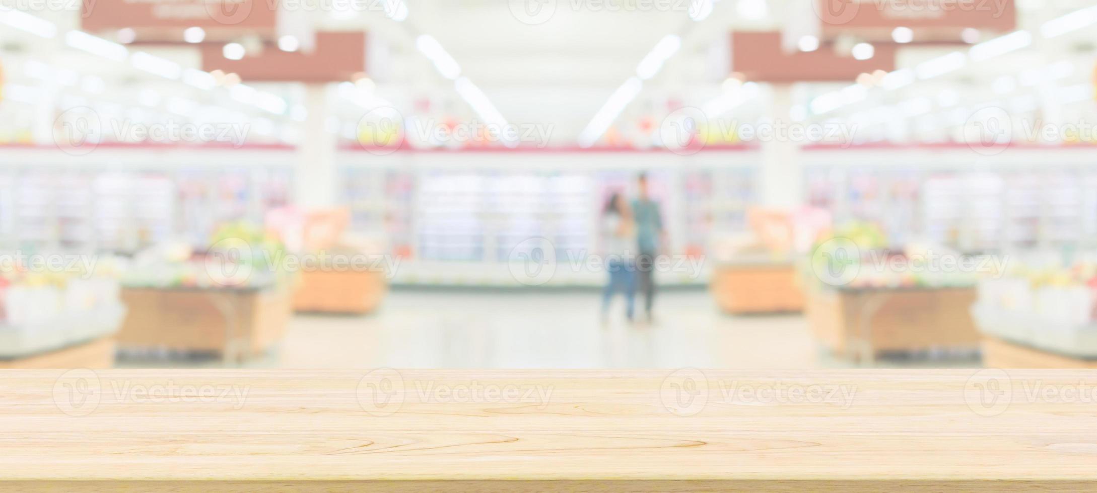Wood table top with supermarket grocery store blurred defocused background with bokeh light for product display photo