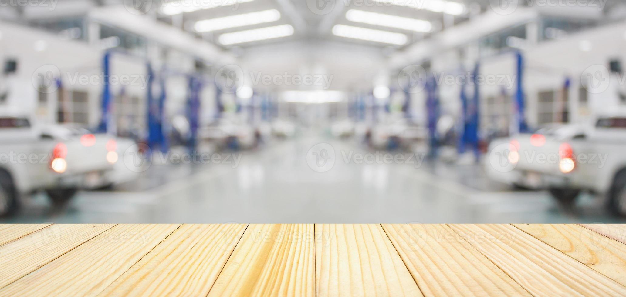 Empty wood table top with car service centre auto repair workshop blurred background photo