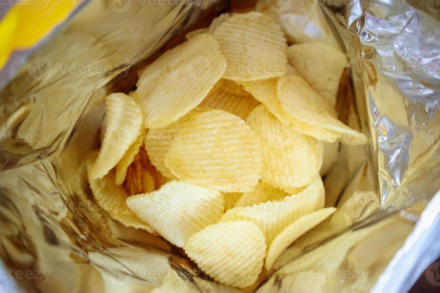 Potato chips in open snack bag close up photo