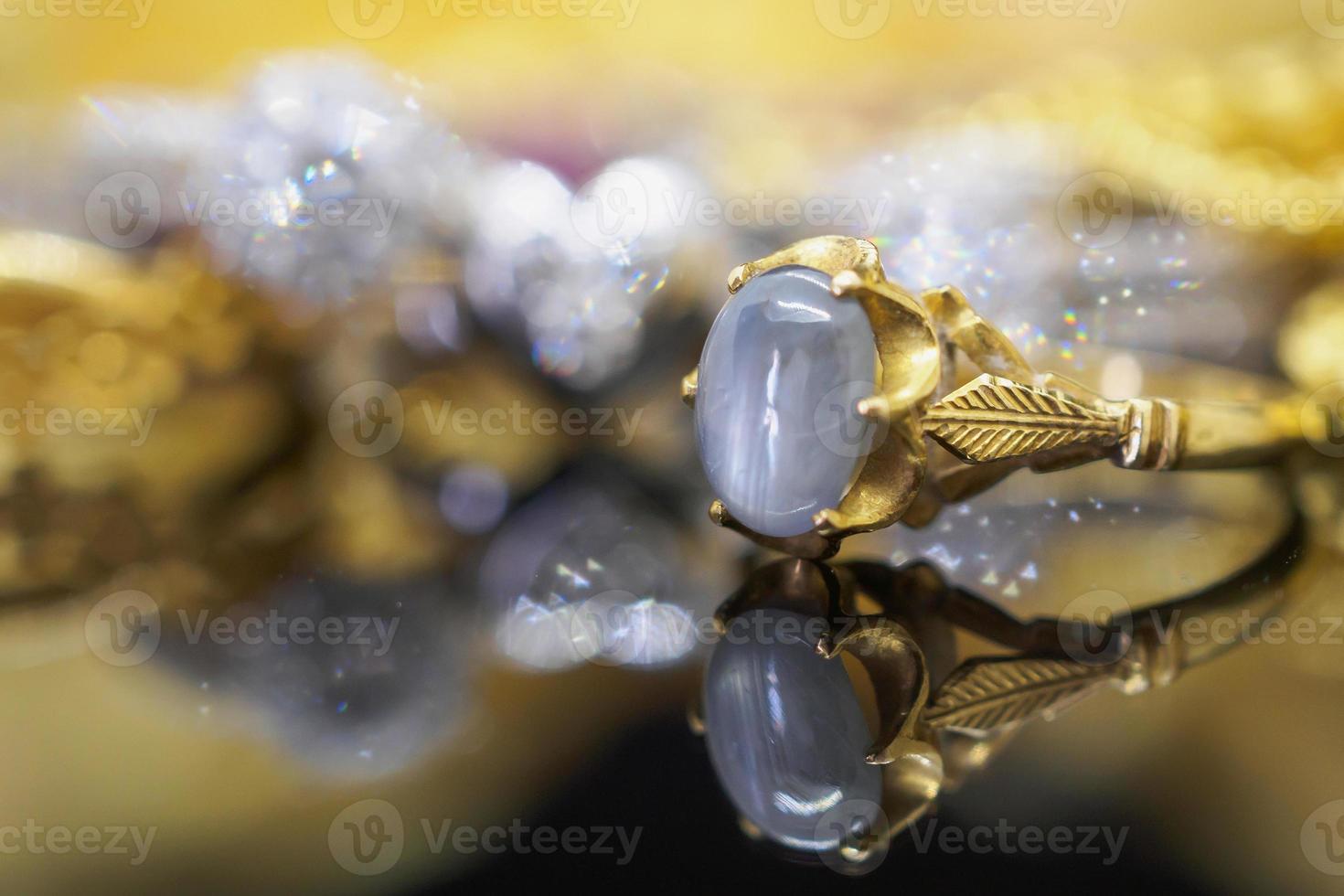 Vintage gold Jewelry blue sapphire rings with reflection on black background photo