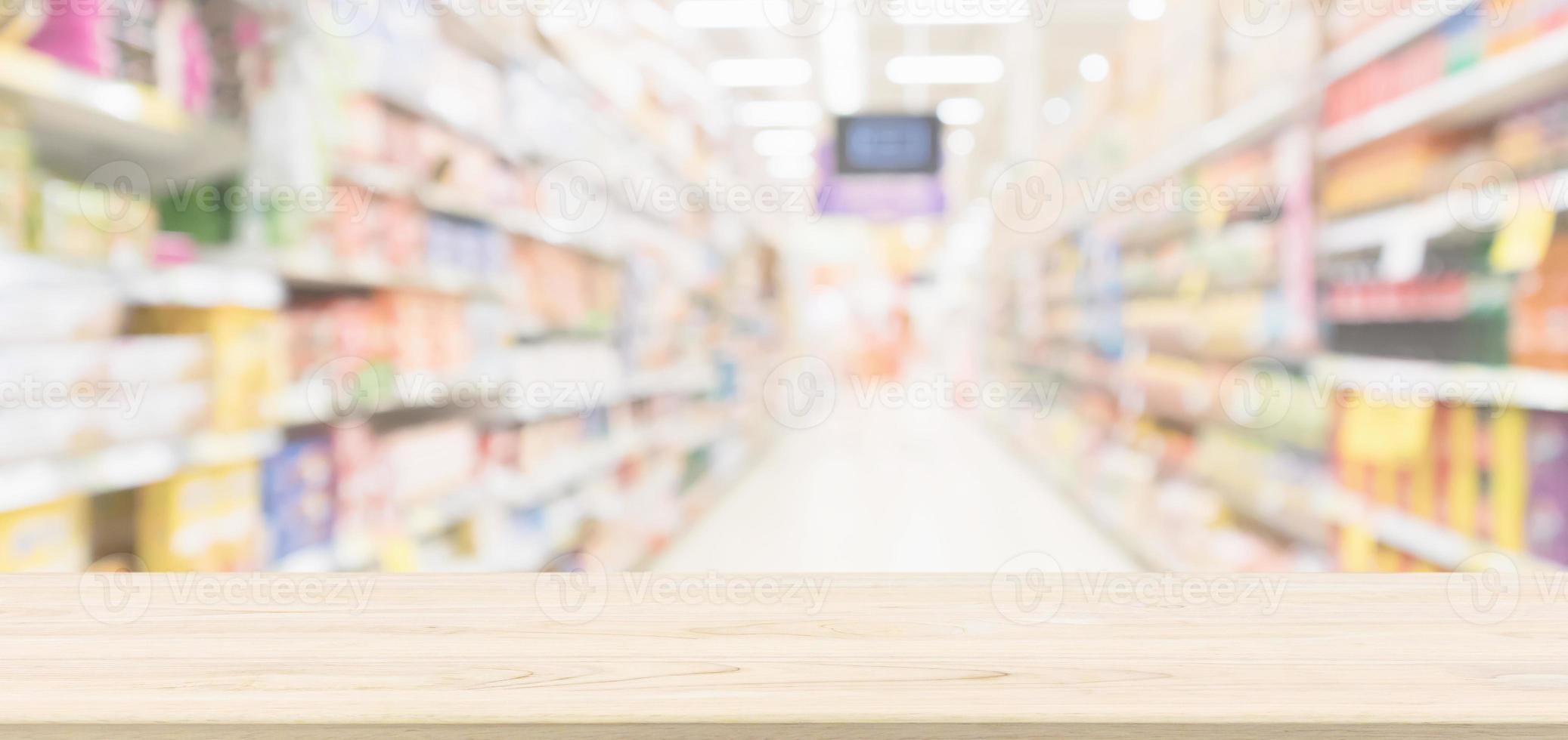 Wood table top with supermarket aisle blur background for product display photo