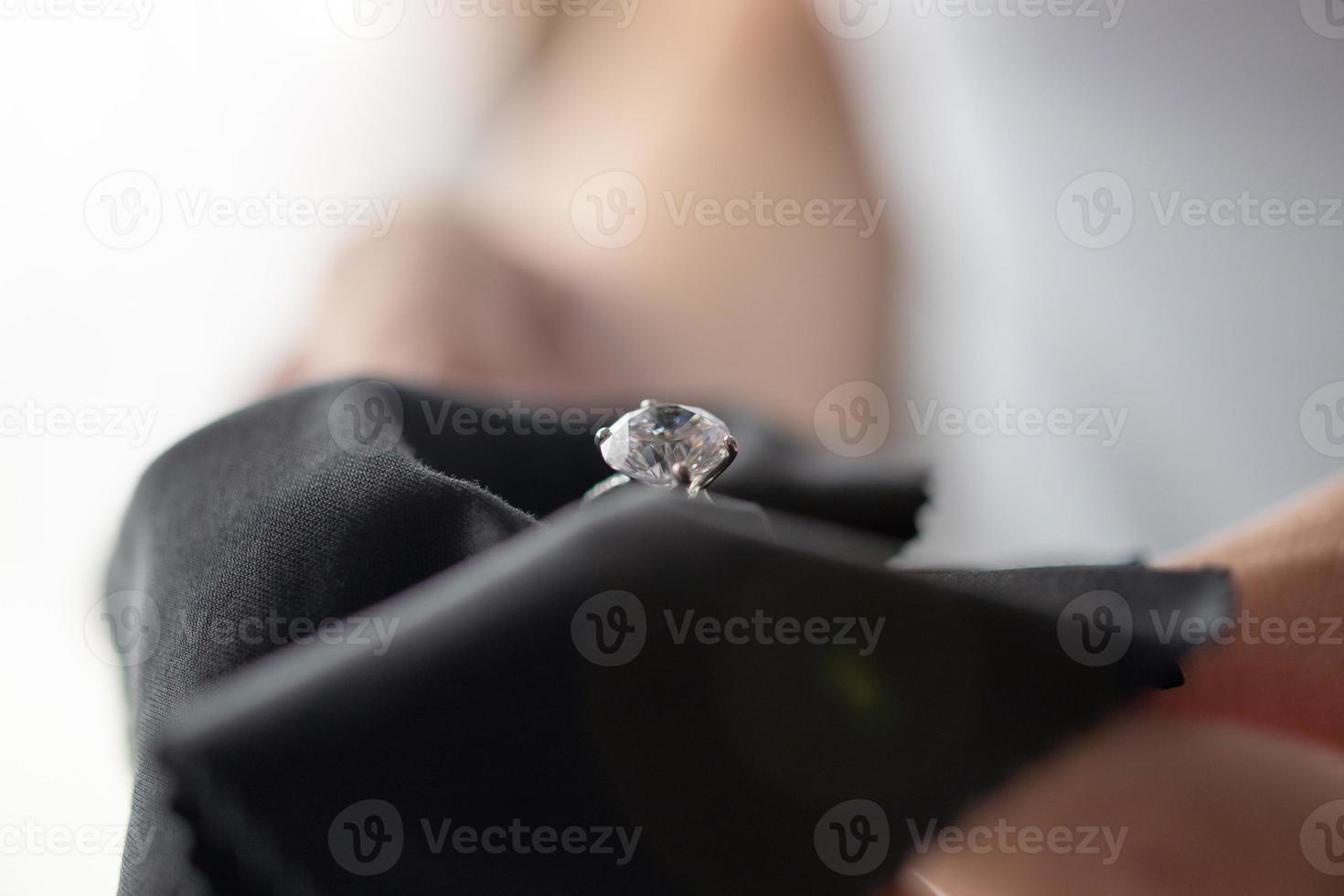 joyero limpieza anillo de diamantes de joyería con paño de tela foto