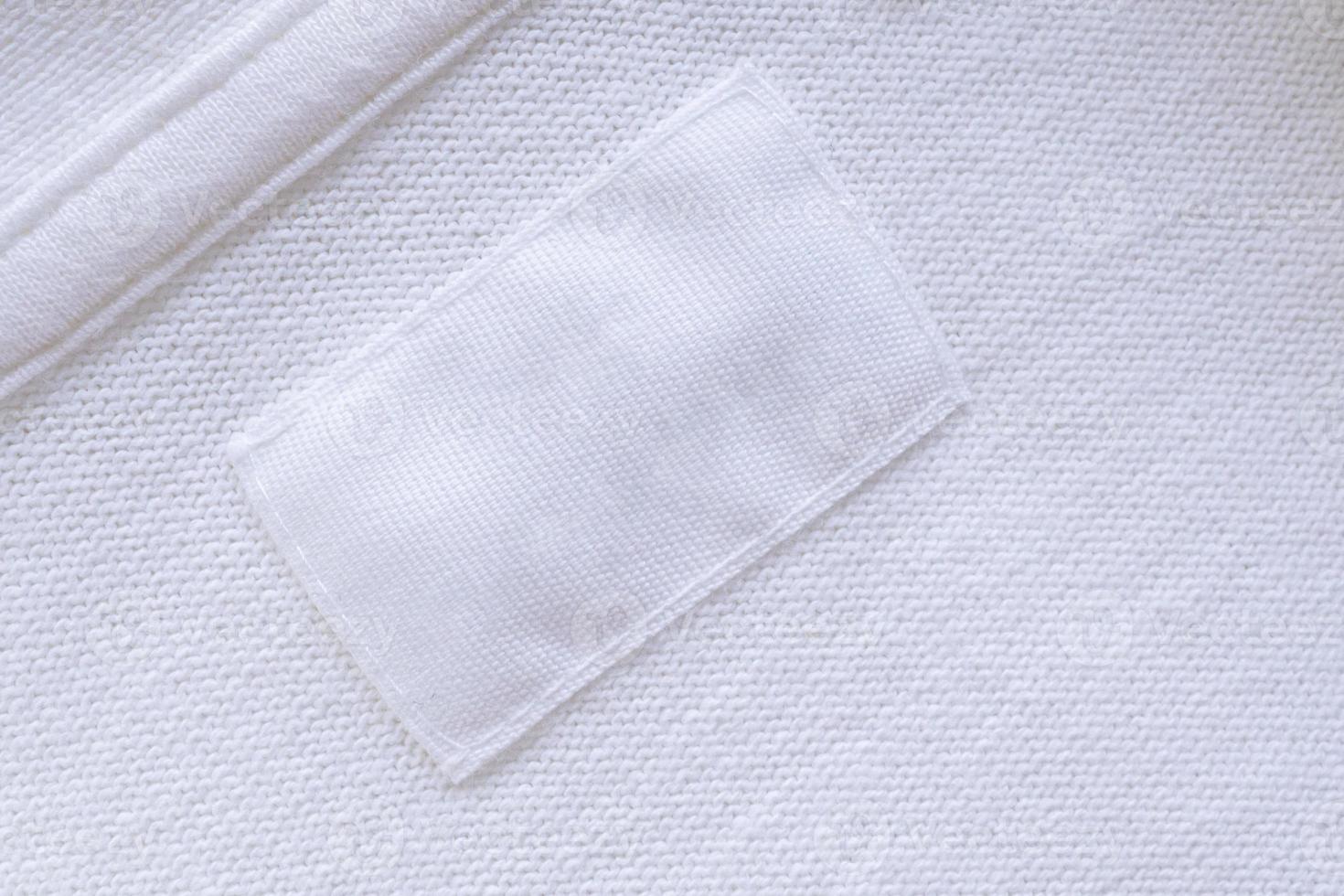 Blank white clothes label on new shirt background photo