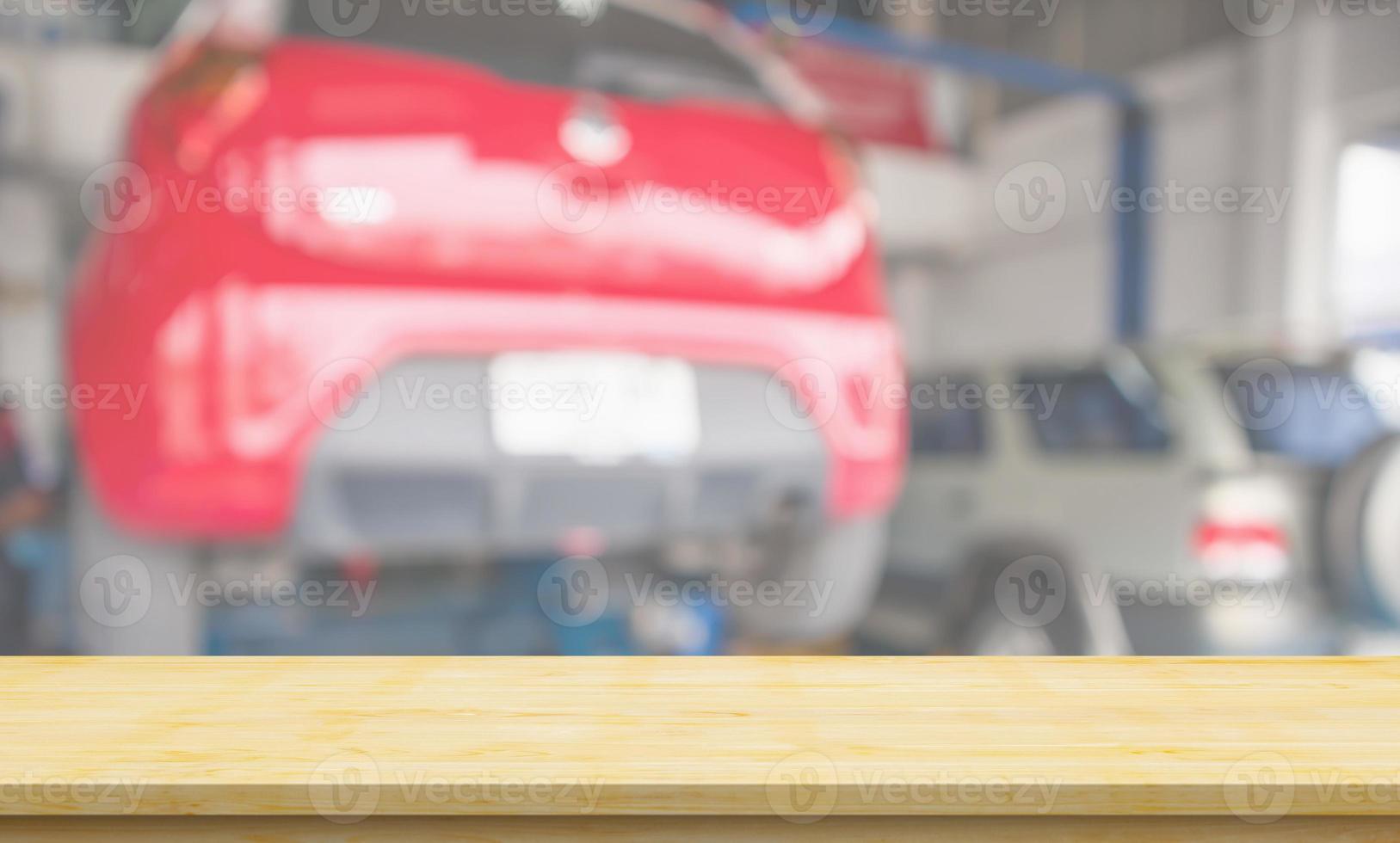 Empty wood table top with car service centre auto repair workshop blurred background photo