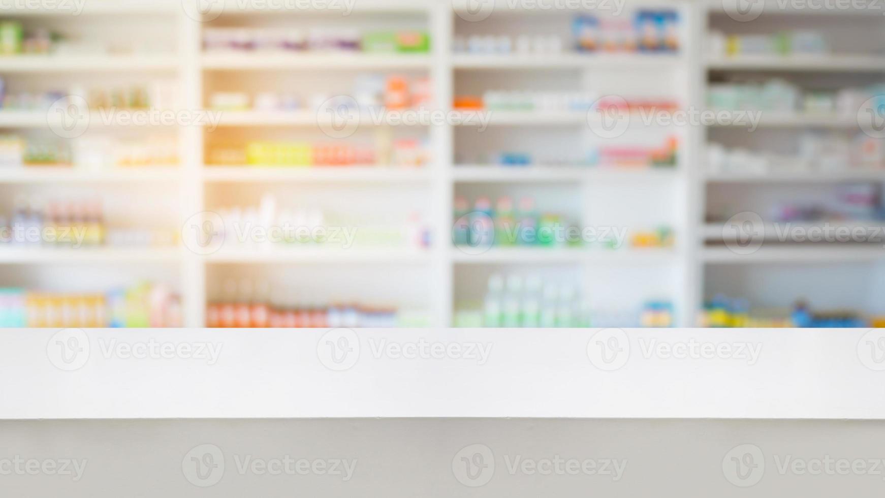mostrador de madera con estantes borrosos de medicamentos en la farmacia foto