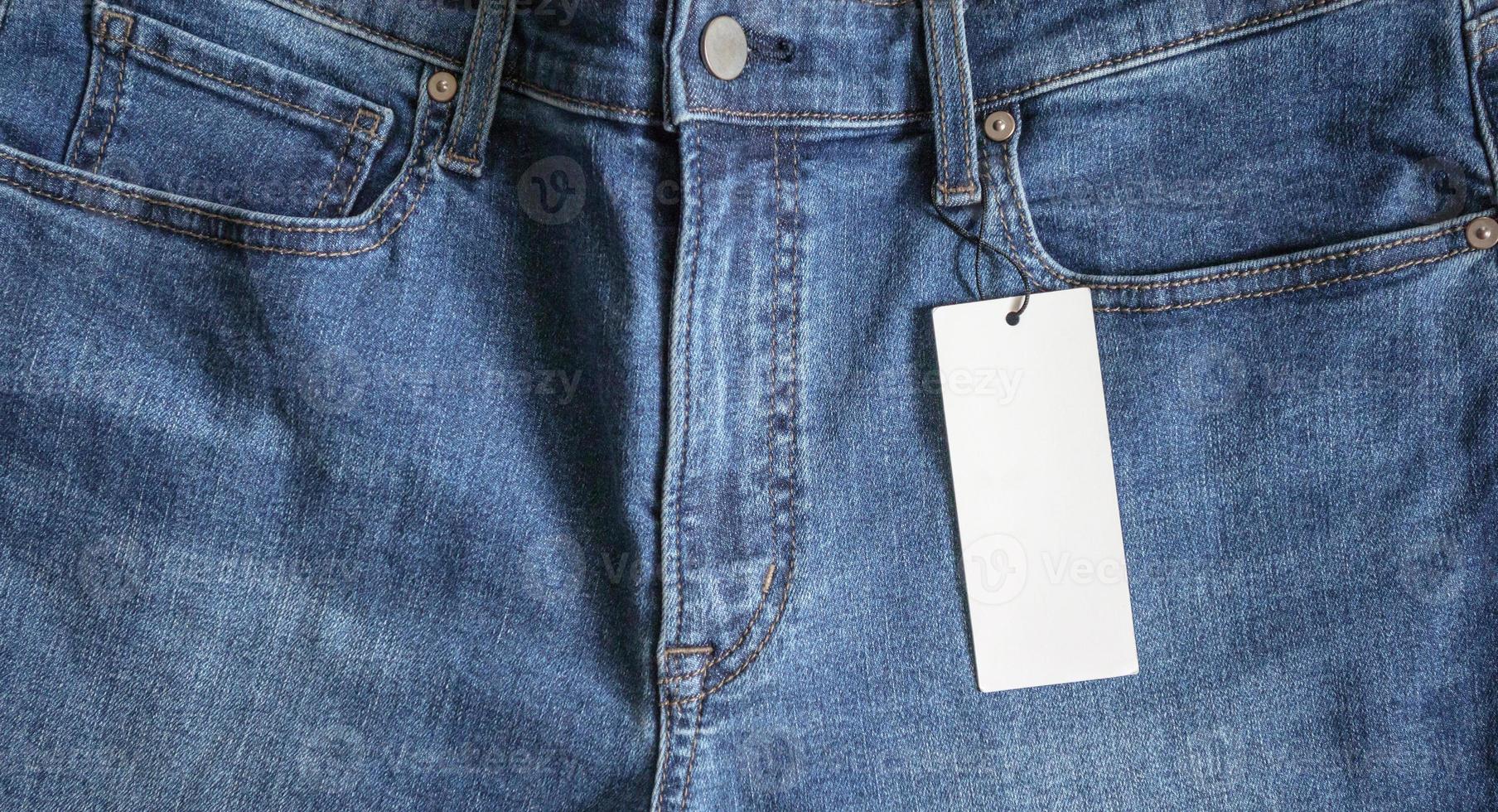 Blue jeans with blank white price label tag photo