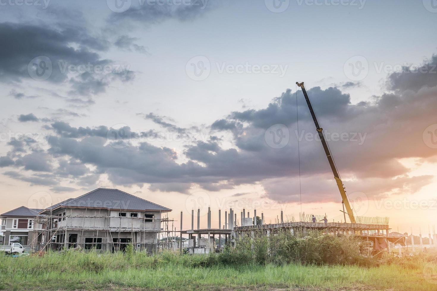 House building at construction site with crane truck photo