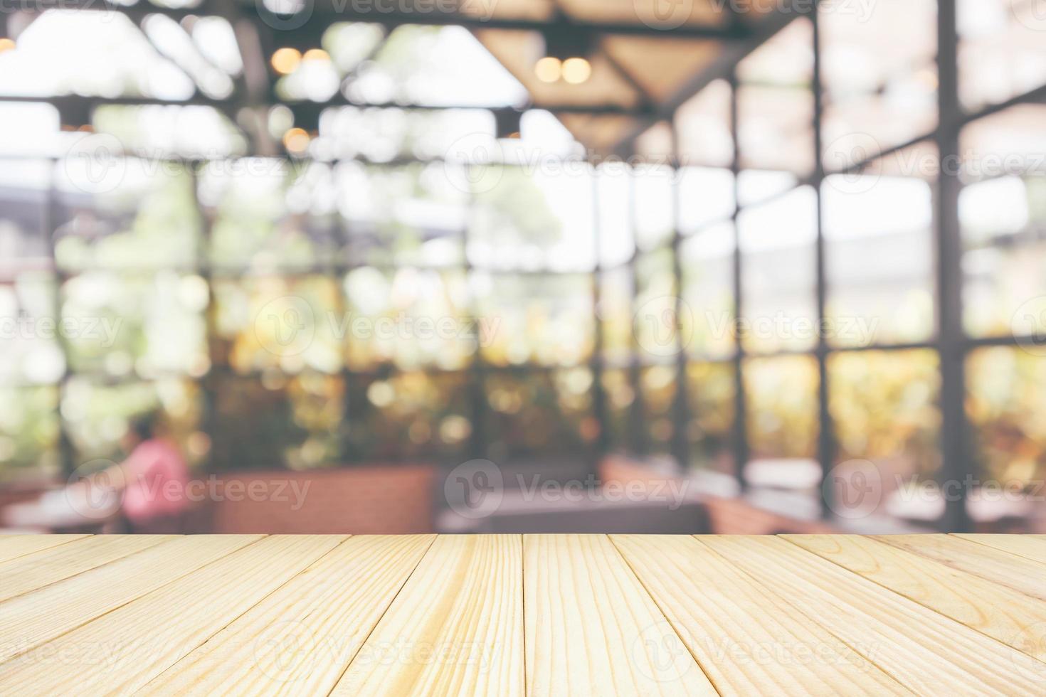 Empty wooden table top with cafe restaurant coffee shop interior abstract blur defocused with bokeh light background for montage product display photo