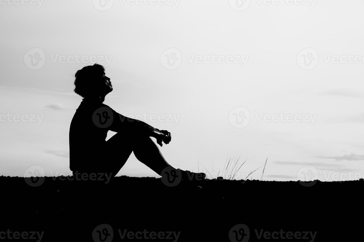 The silhouettes of men are sitting in despair. The concept was discouraged and hopeless. photo