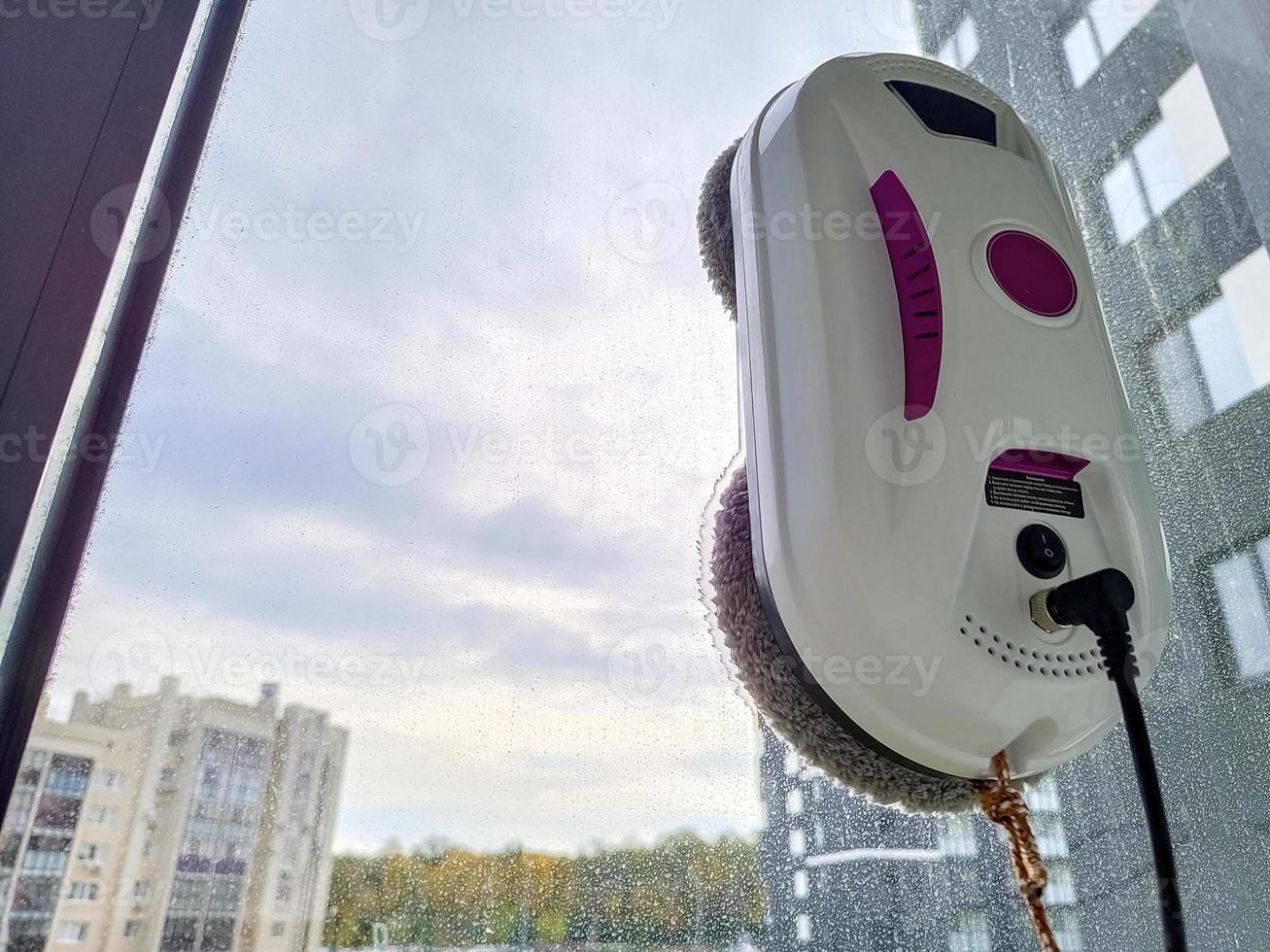 Vacuum cleaner robot washing glass window. Robot window cleaner photo