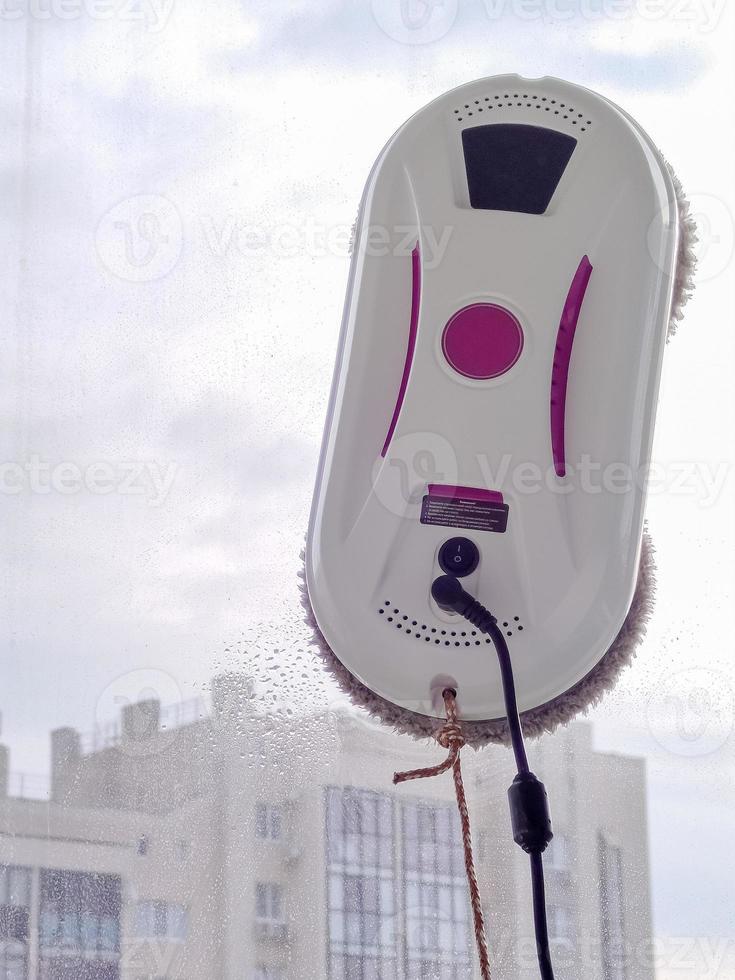 Vacuum cleaner robot washing glass window. Robot window cleaner photo