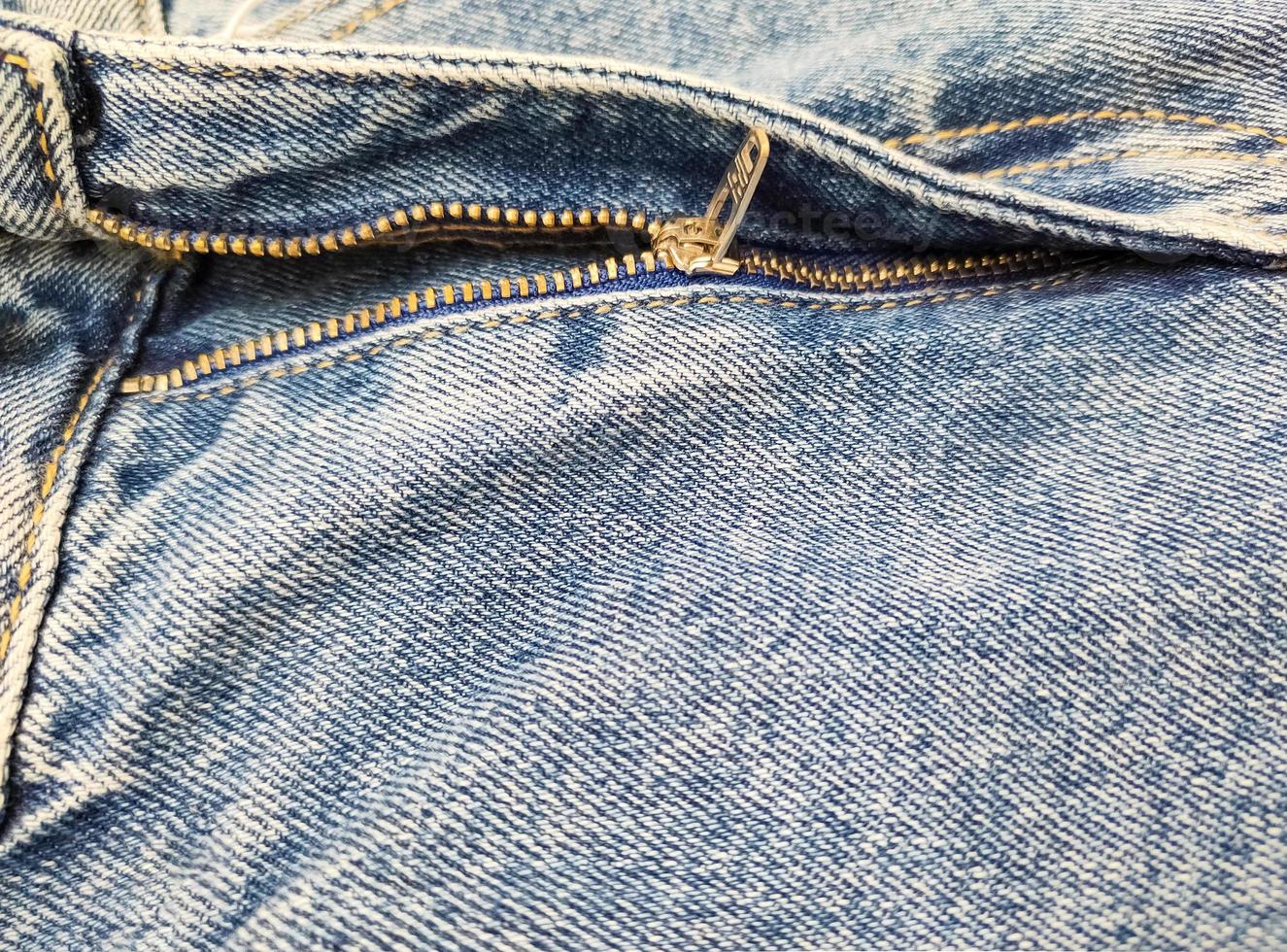 Zipper on jeans. Jeans texture. Close-up denim background. Unzipped jeans. photo