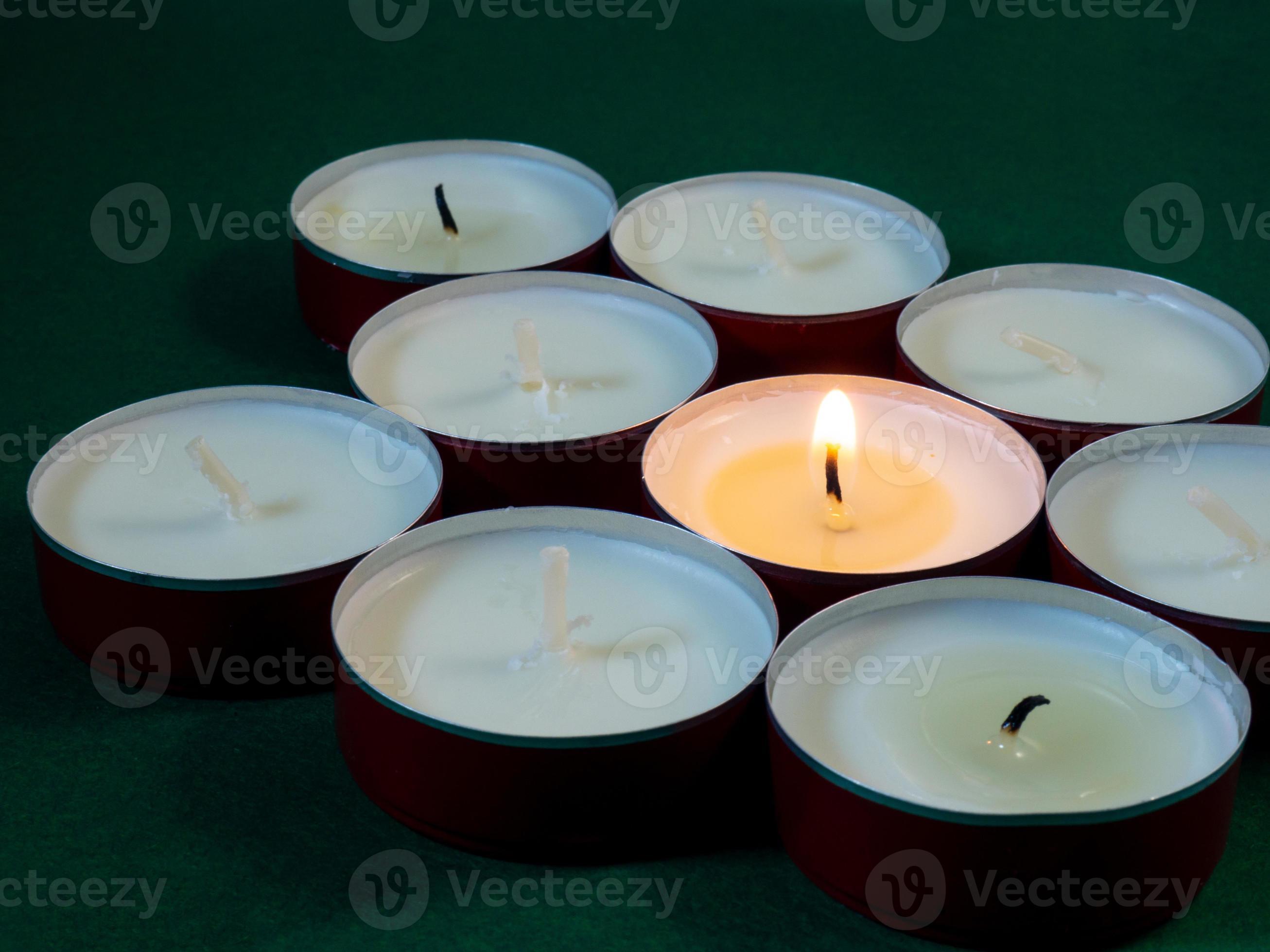 velas cortas arden sobre una superficie verde. muchas velas pequeñas. No  todas las velas están encendidas. 12813169 Foto de stock en Vecteezy