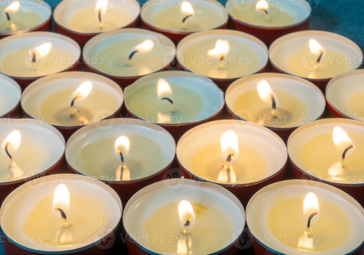 Lots of small lit candles. Dark mysterious atmosphere.  Flat round candles photo