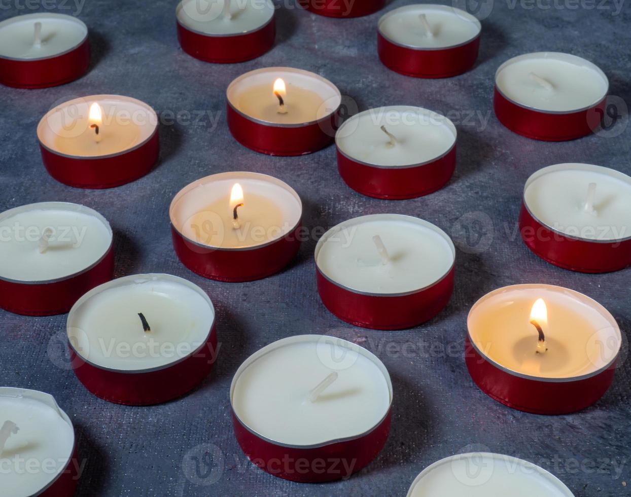 https://static.vecteezy.com/system/resources/previews/012/813/201/non_2x/short-candles-are-burning-against-a-dark-background-lots-of-small-candles-not-all-candles-are-lit-photo.jpg