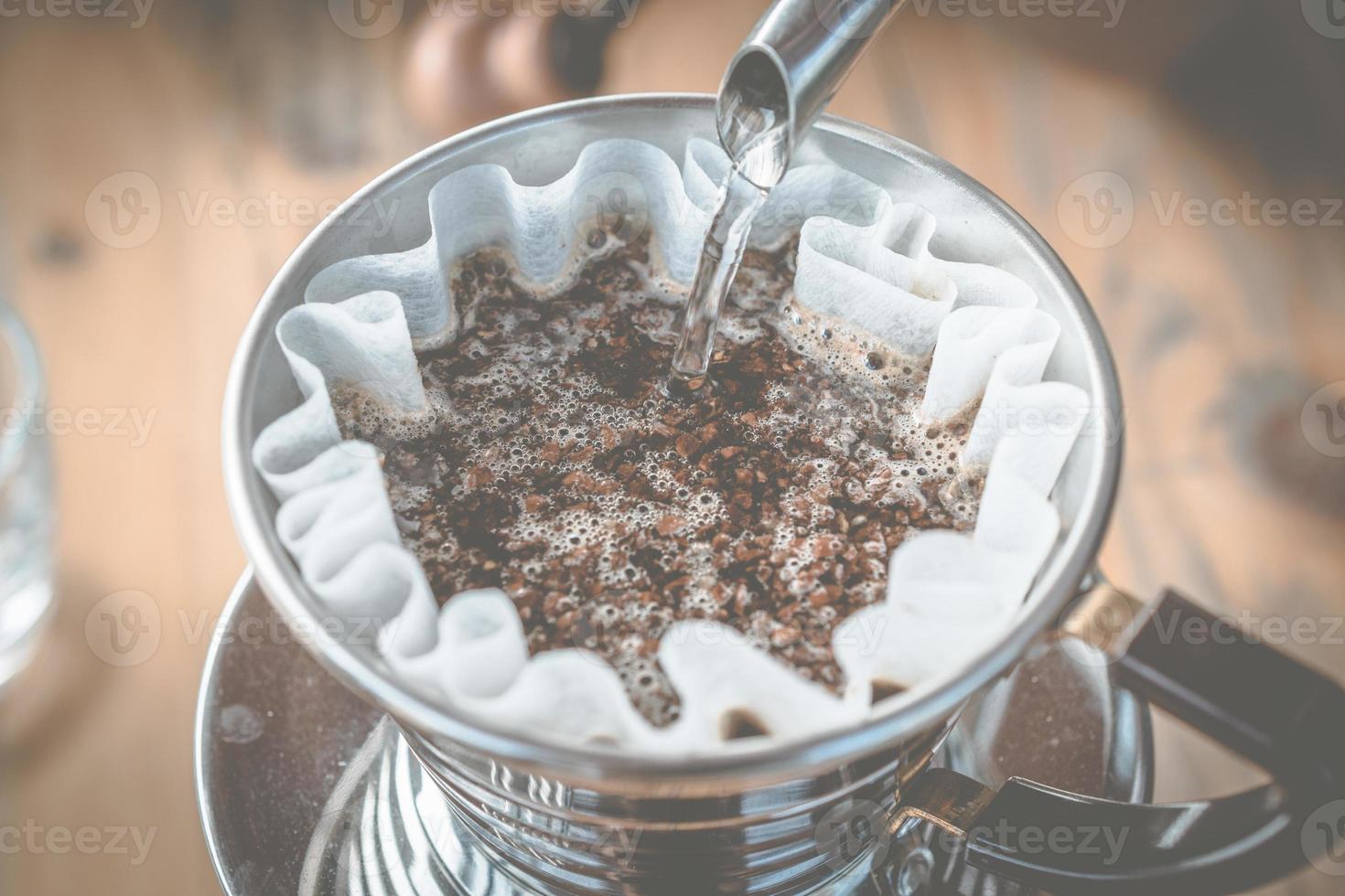 barista vertiendo agua caliente en café molido con filtro para hacer un café de inmersión. foto