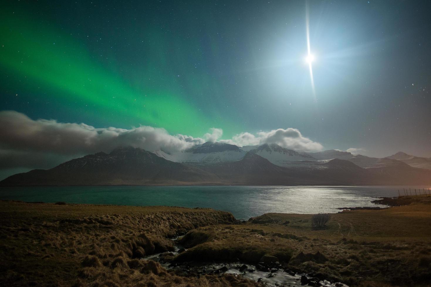 The beautiful Aurora Borealis over the mountains fjord in Stoovarfjorour of East Iceland. photo