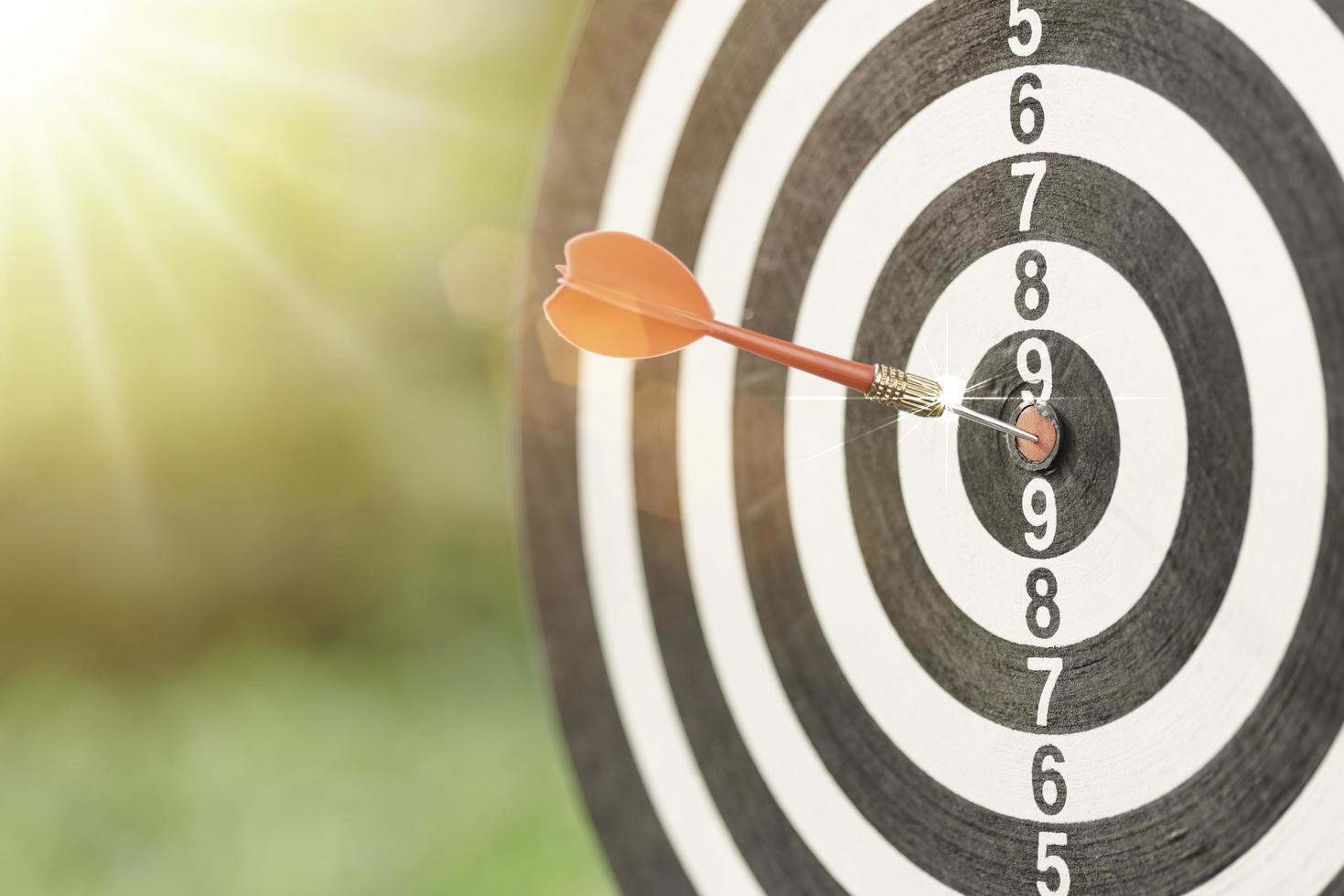 dart arrow hitting in the target center of dartboard, setting business goals, formulating success strategies and goals, planning and managing the future for business growth. photo