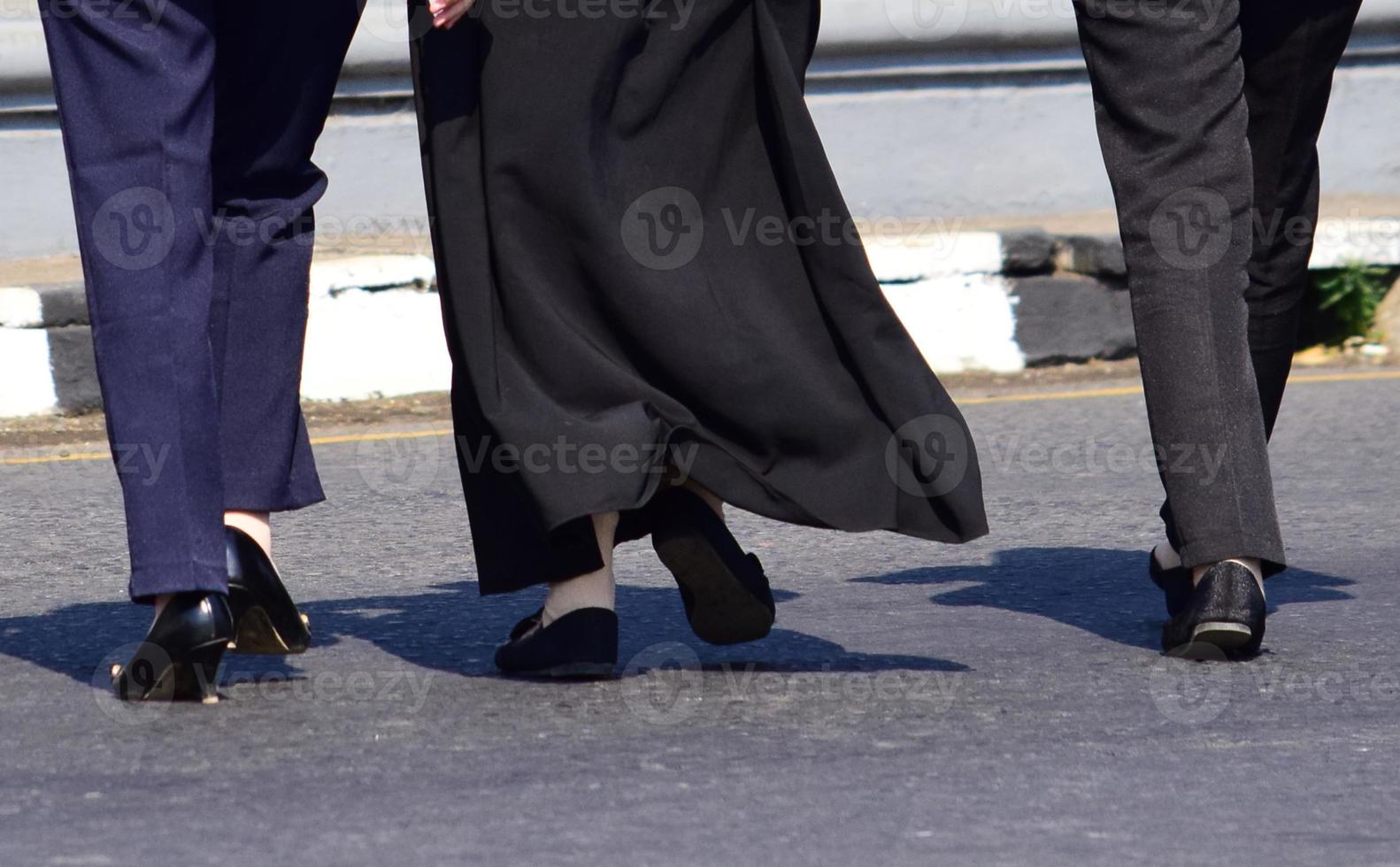 Close up of woman's feet walking. Woman in long skirt and black shoes walking photo