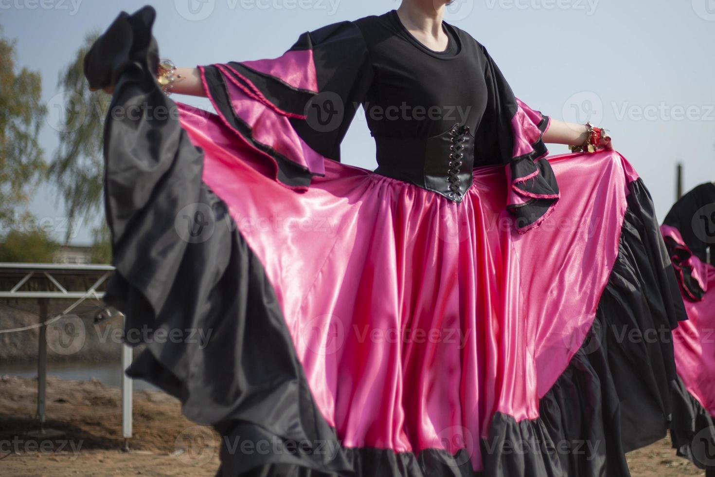 Gypsy dances in bright dresses. Girls dance on street Spanish dance. Bright fabric. photo