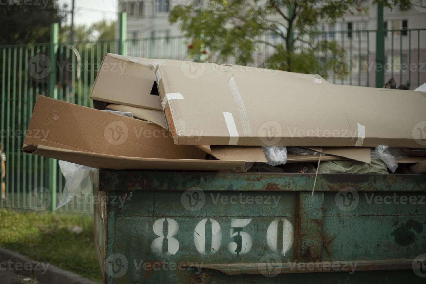 Cardboard in dumpster. Garbage can outside. Discarded cardboard. 12815357 Stock Photo at Vecteezy