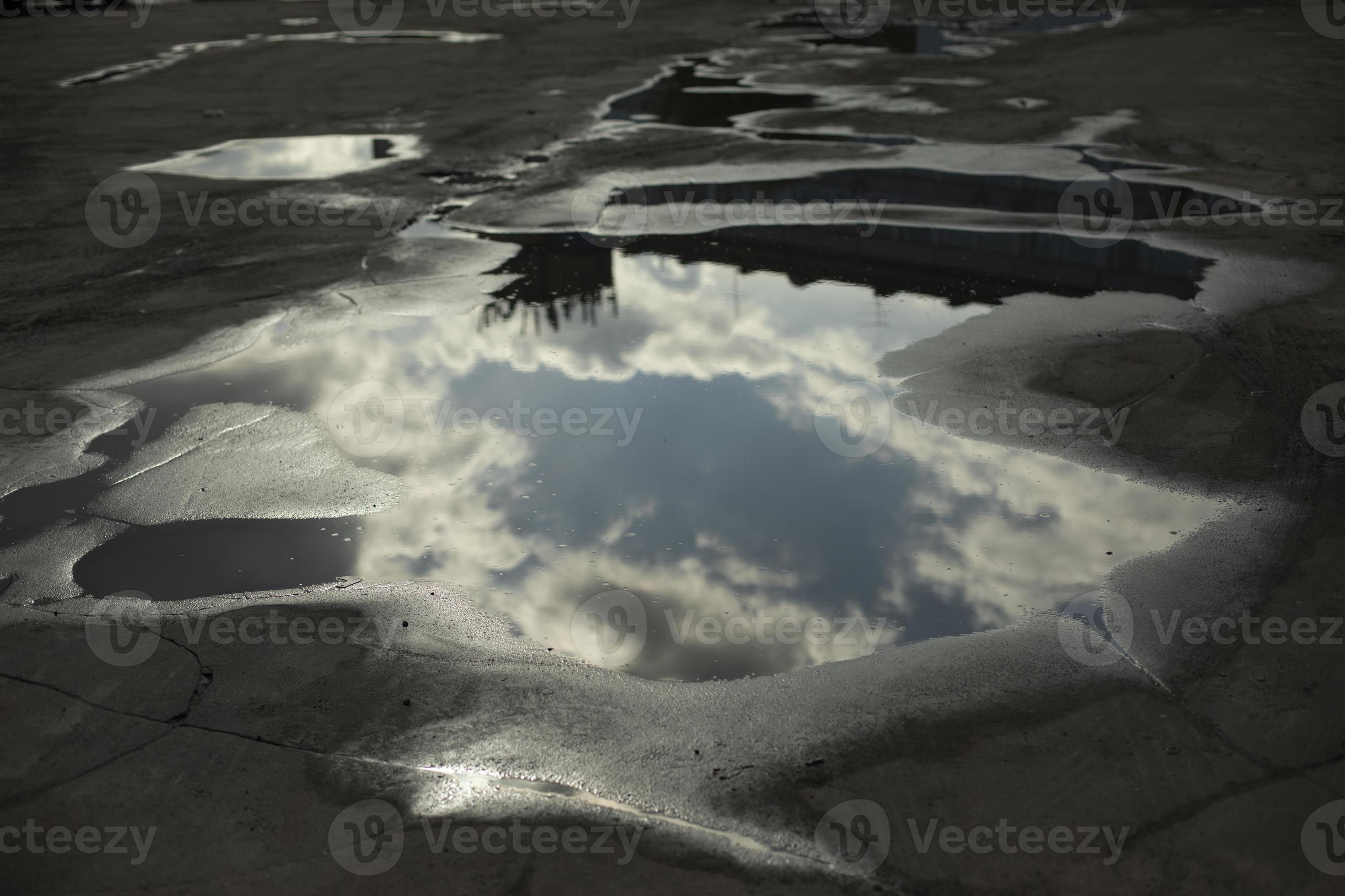 gran charco en la carretera. reflejo del cielo en charco. agua sobre
