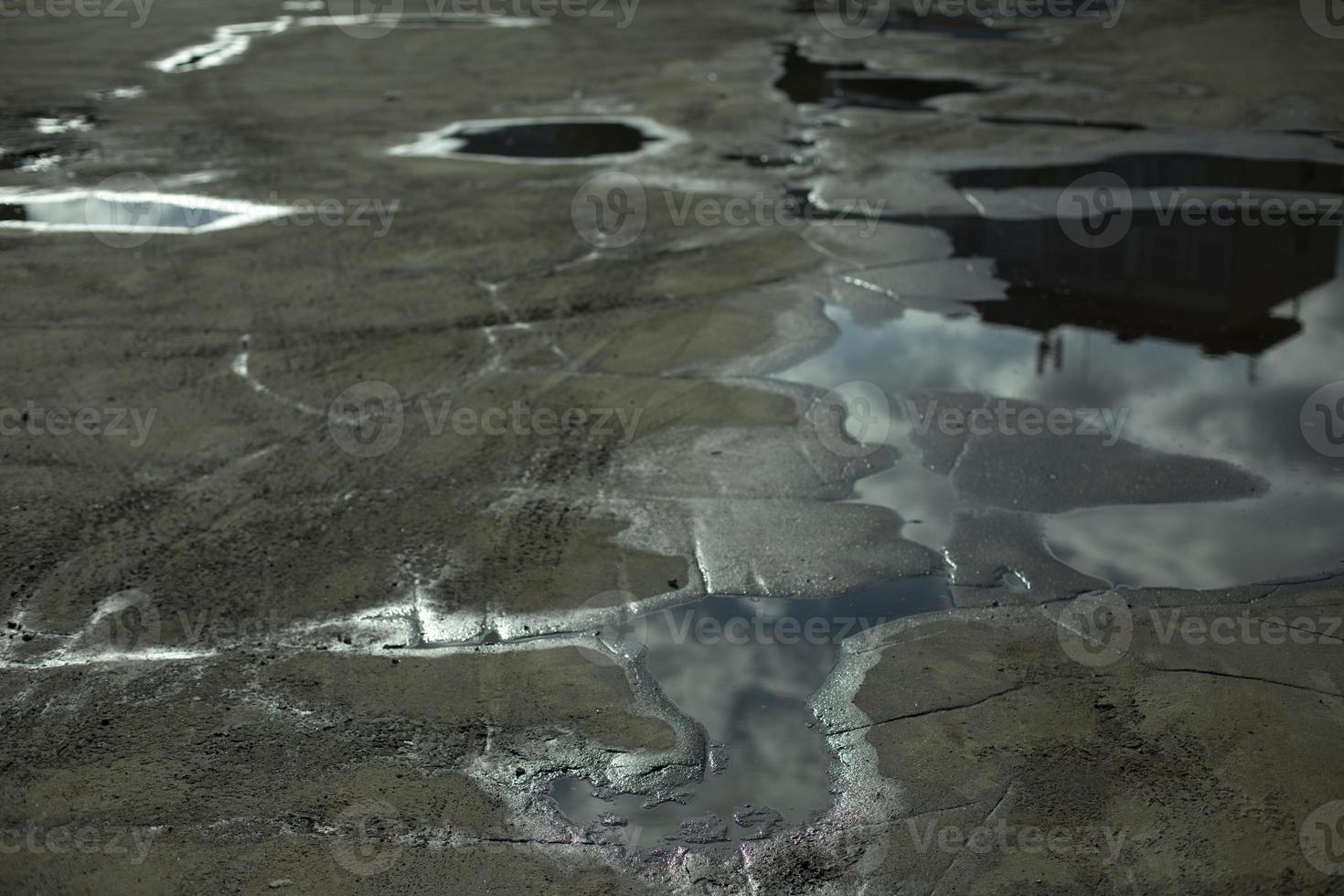 Big puddle in road. Reflection of sky in puddle. Water on asphalt. photo