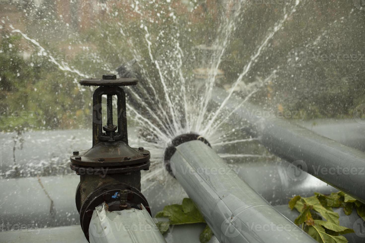 Pipeline accident. Boiling water pours from pipe. Boiler room emergency. photo