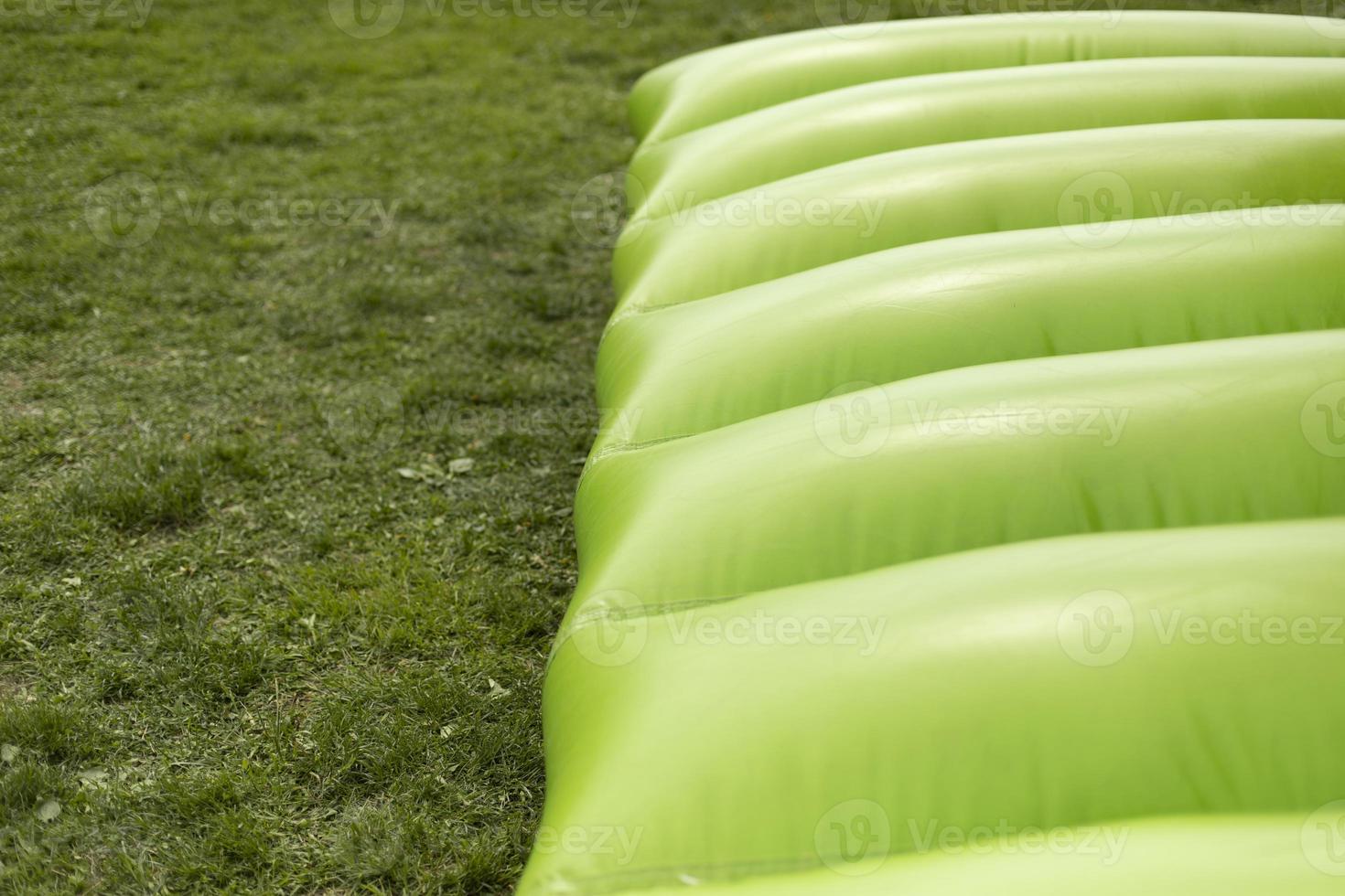 Green trampoline. Inflatable slide. Obstacle course. Entertainment in park. photo