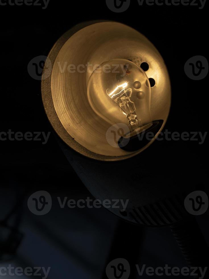 Table lamp in dark. Incandescent lamp in interior. photo