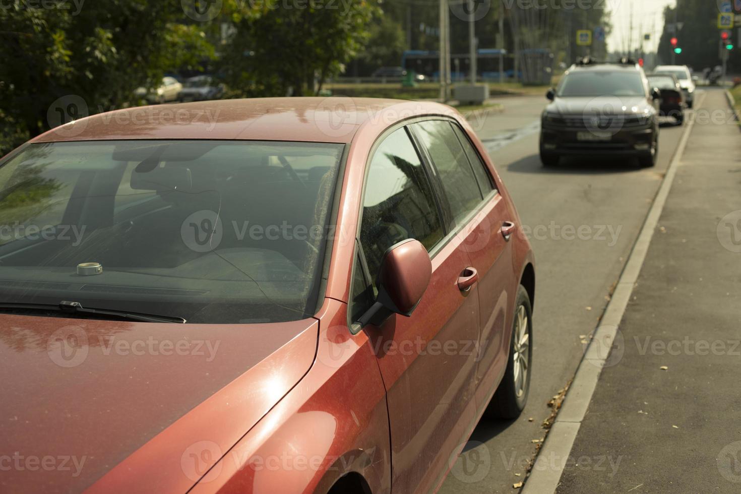 Red car in parking lot. Car is on side of road. Transport in city in summer. photo