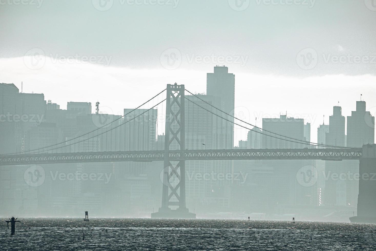 Famous Bay Bridge and city skyline with sky in background at seafront photo