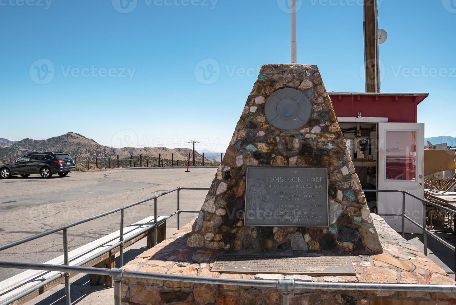 Sign on memorial structure by road in vintage city with blue sky in background photo