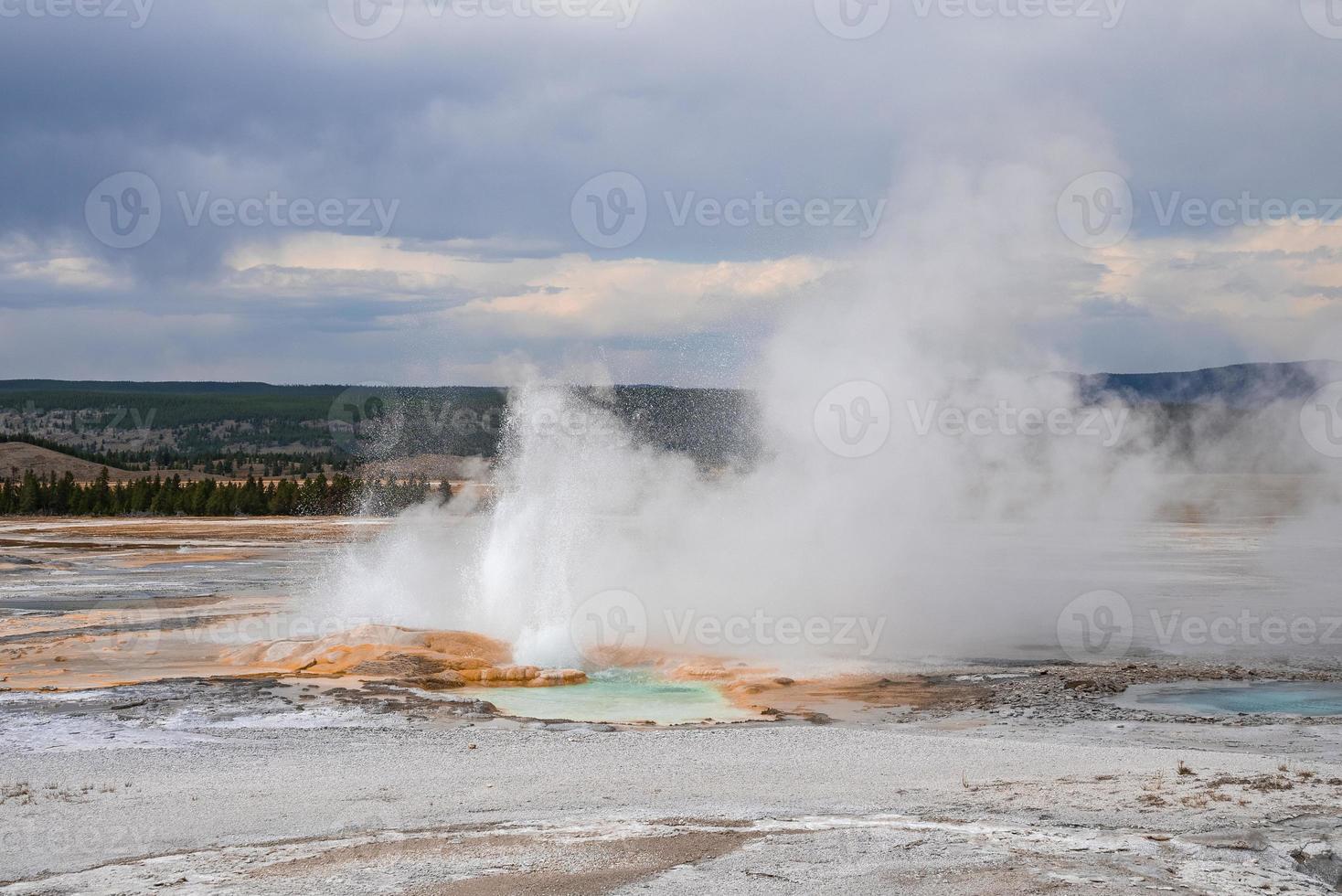 View of eruption of Clepsydra Geyser in forest at Yellowstone national park photo