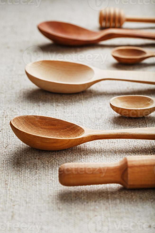 Natural wood spoons in a row on burlap fabric. Natural natural materials. photo