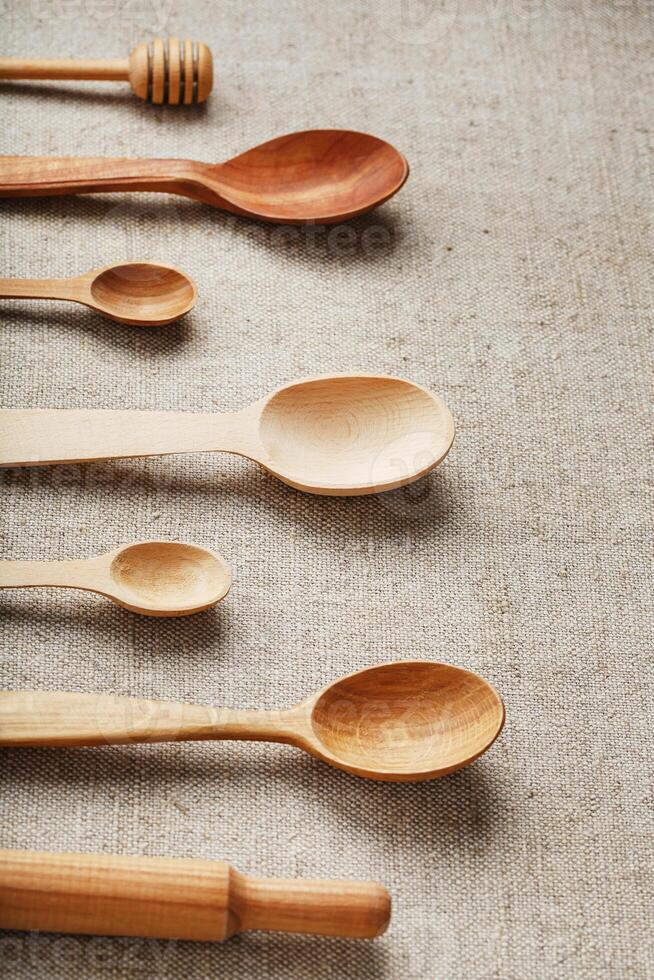 Natural wood spoons in a row on burlap fabric. Natural natural