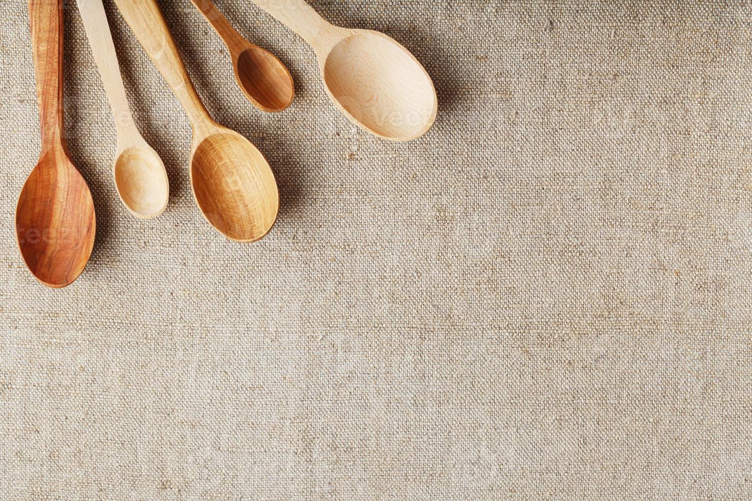 Wooden spoons made of natural wood on burlap fabric as a craft. photo