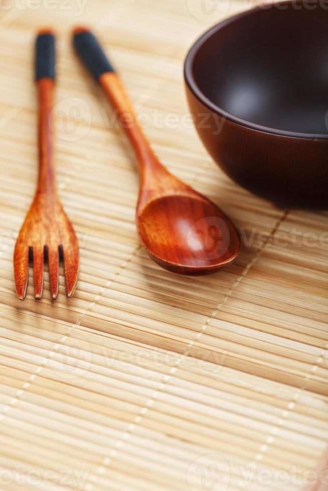 Utensils made of wood, bowl and spoons on a cutting board on a white background photo