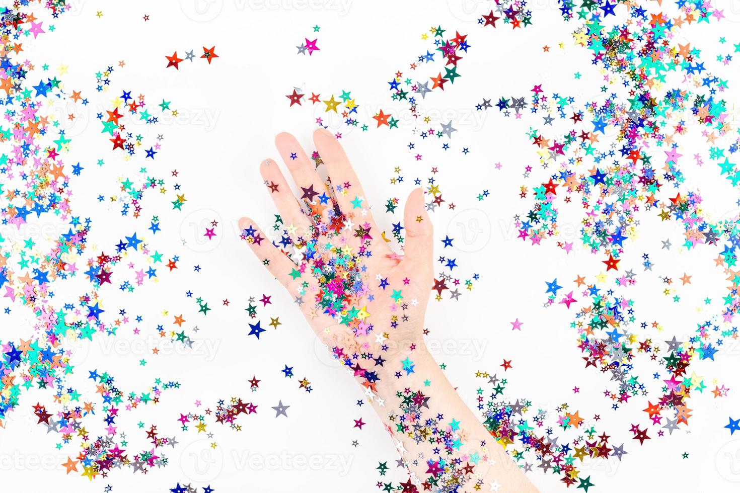 Woman hand with festive color star confetti photo