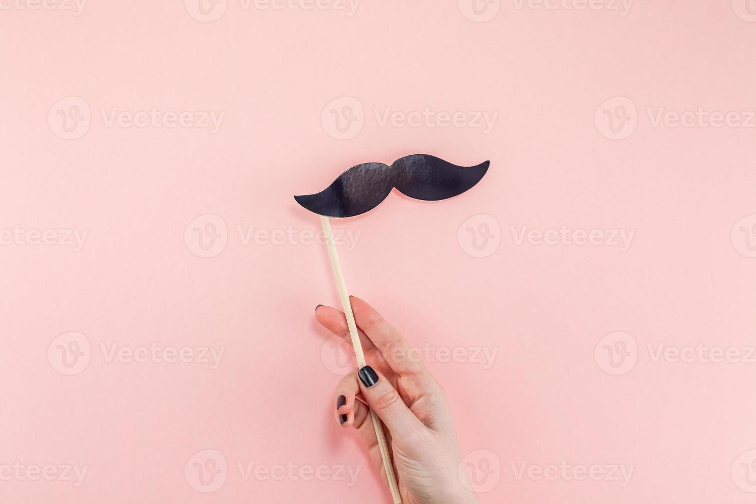 Woman hands with black paper moustaches photo