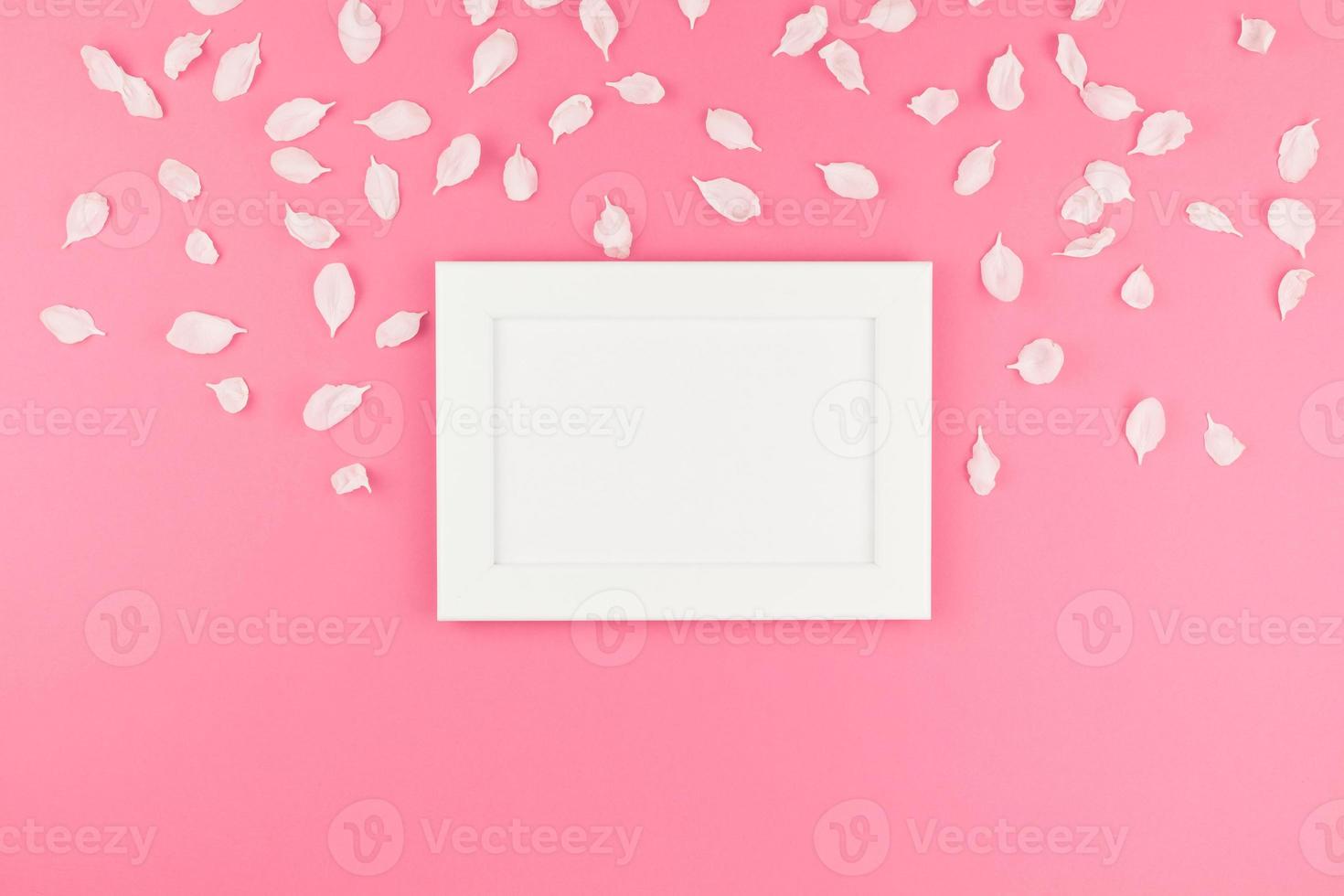 Flat lay of white frame mock up with petals photo