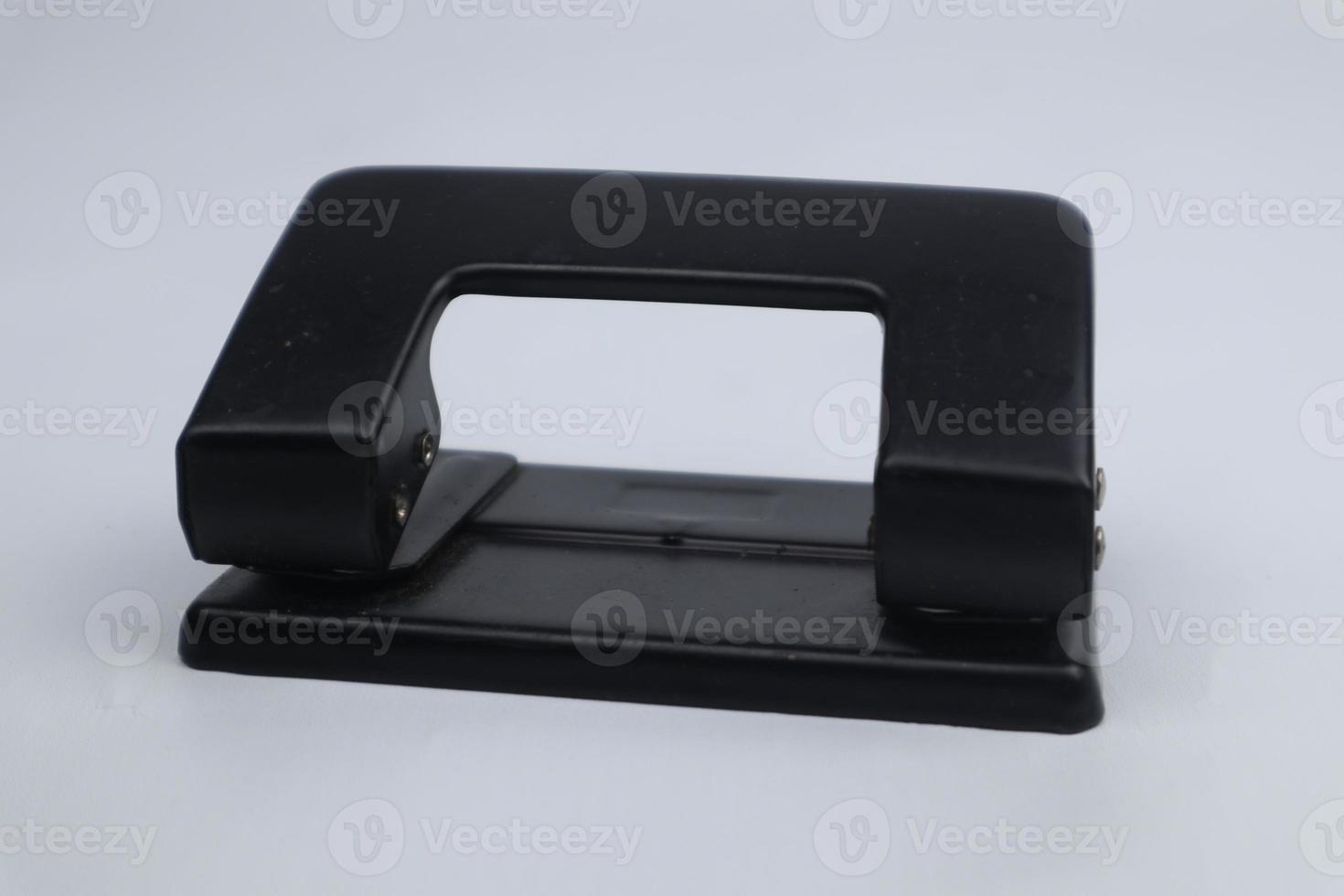 Office paper perforator isolated on white background. Office tool that is used to create holes in sheets of paper. Paper Metal Stationary Hole Puncher. Office file-punch photo