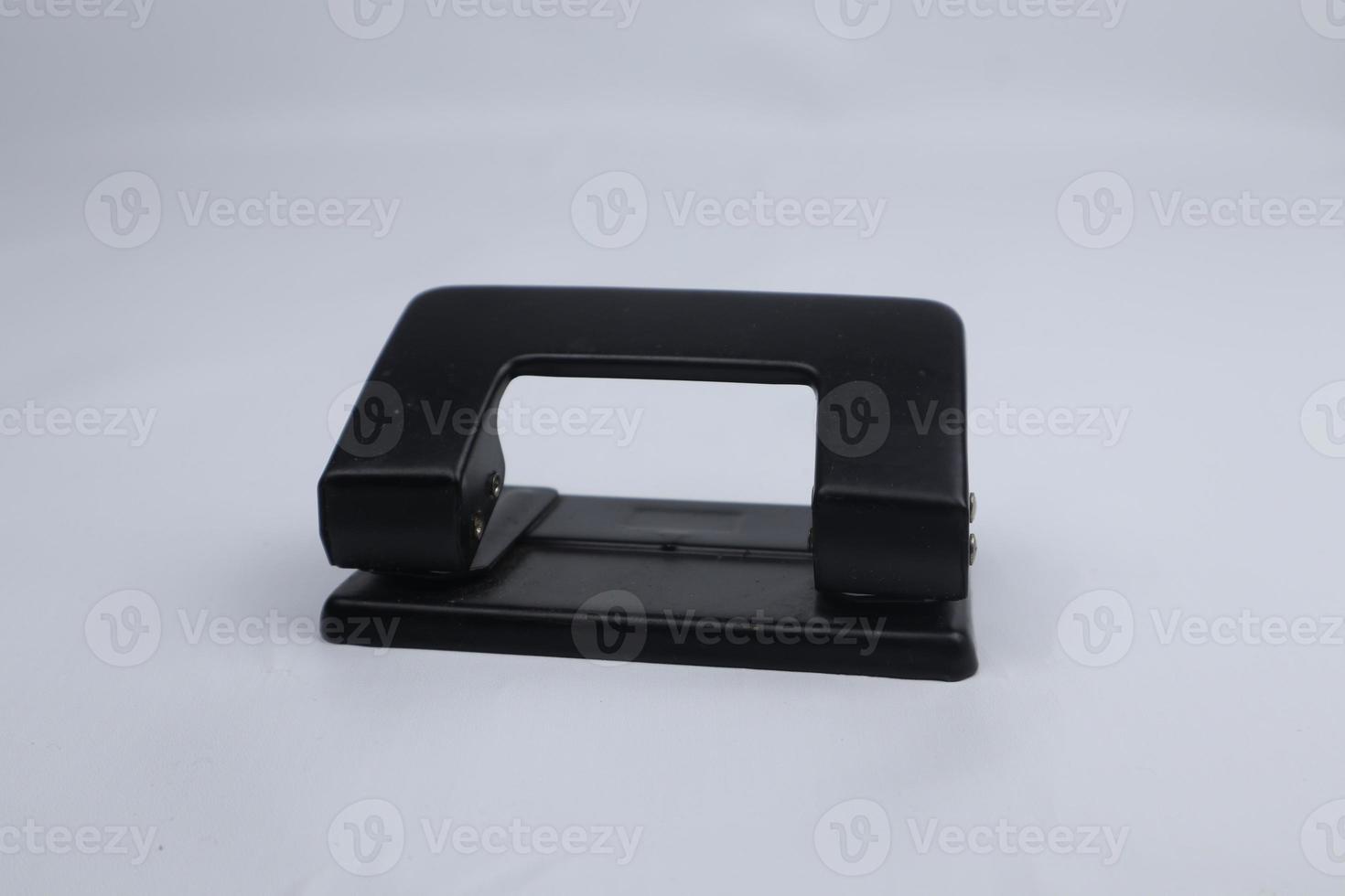 Office paper perforator isolated on white background. Office tool that is used to create holes in sheets of paper. Paper Metal Stationary Hole Puncher. Office file-punch photo