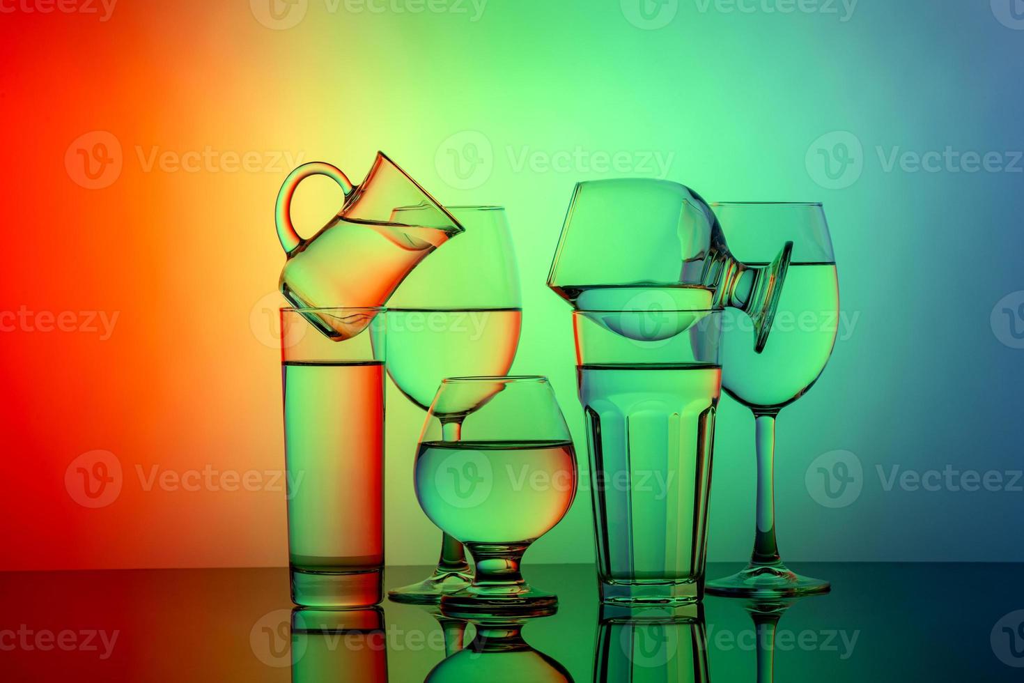 Some glasses for different drinks stacked on a colorful background photo