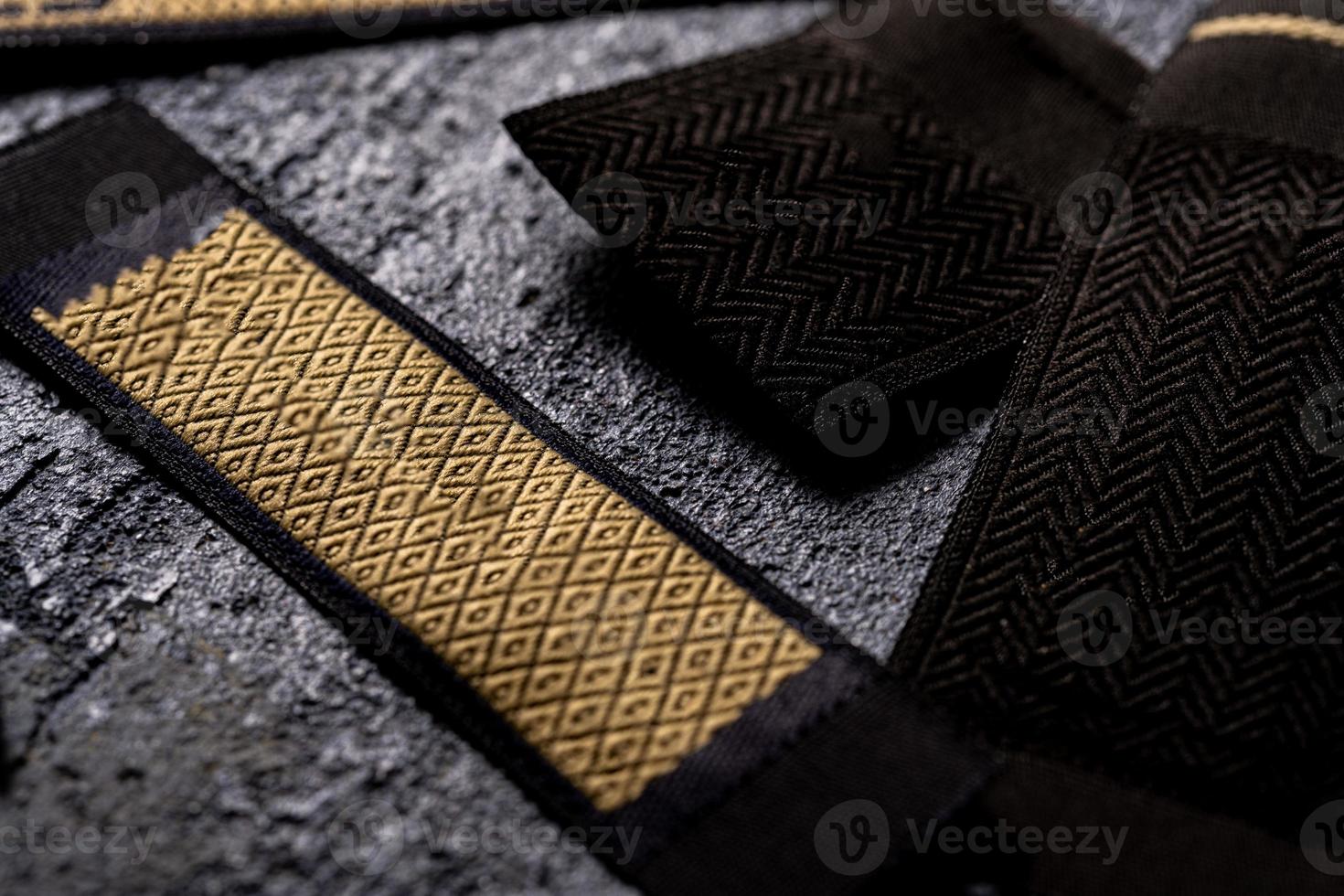 A closeup shot of strips of patterned black and gold fabric for fashion design photo