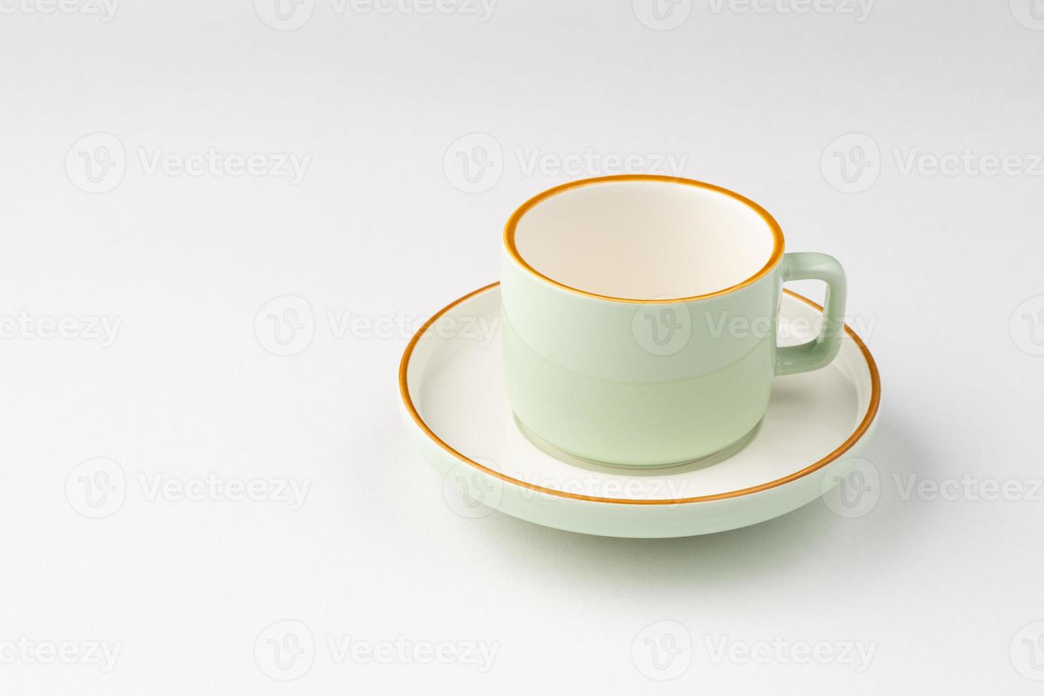 una taza de té de cerámica blanca y verde pastel con contornos naranjas foto