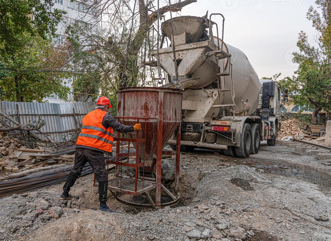 Worker on a construction site building infrastructure with machinery and tools. Pouring concrete photo