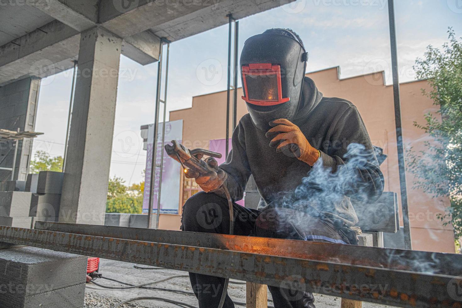 A working welder makes a metal structure in a new building infrastructure photo